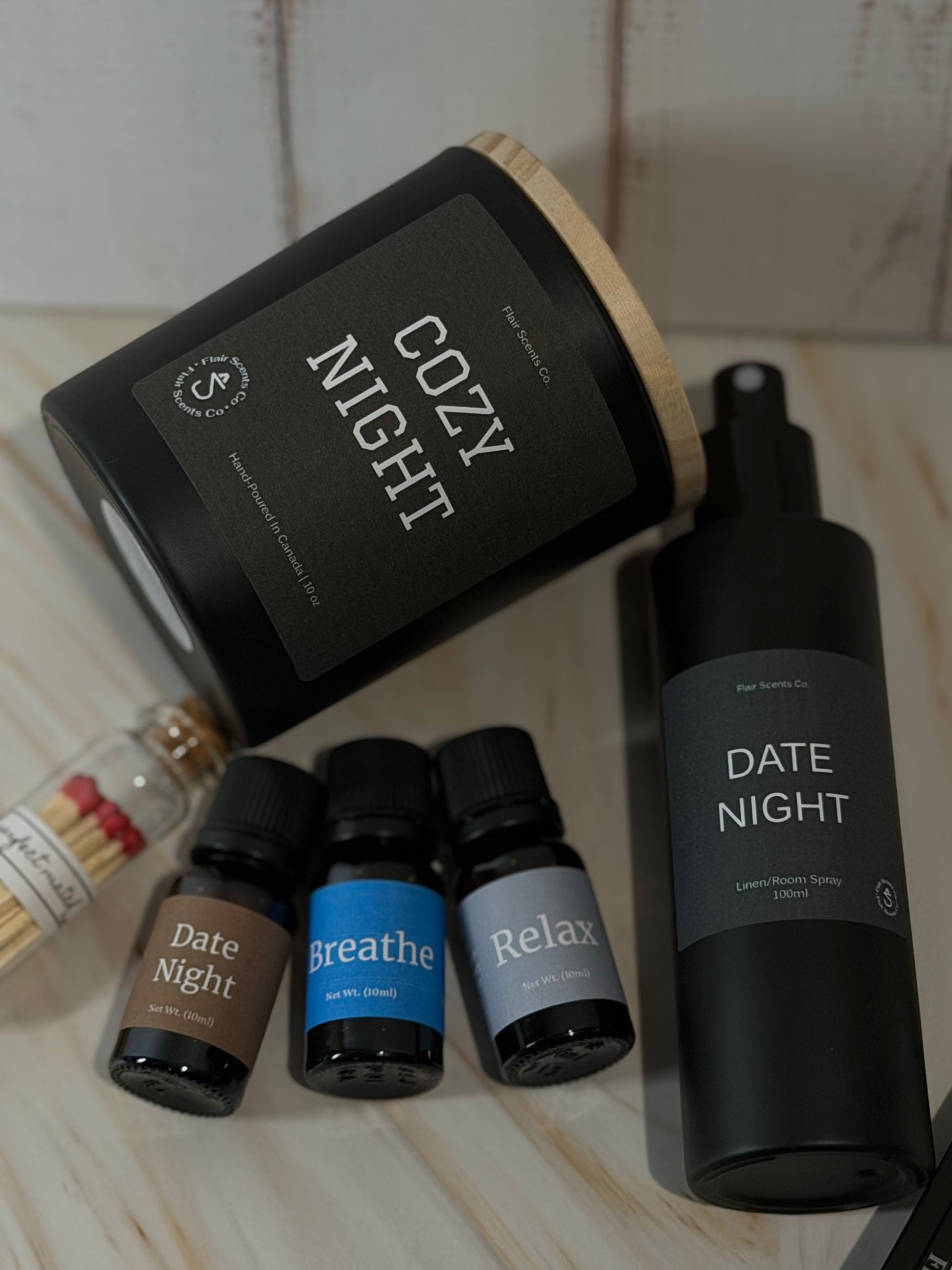 Evening Reset Bundle night routine self-care set featuring a calming candle, room spray, essential oil, wick trimmer, and match sticks arranged in a peaceful home setting.