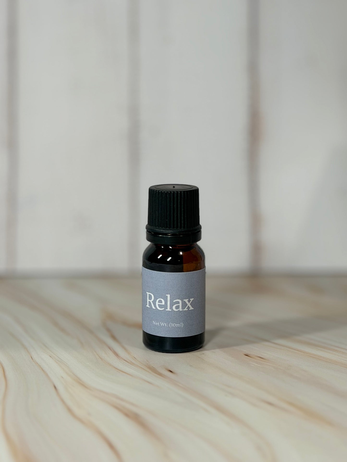 bottle of Relax essential oil blend with eucalyptus spearmint on wooden surface