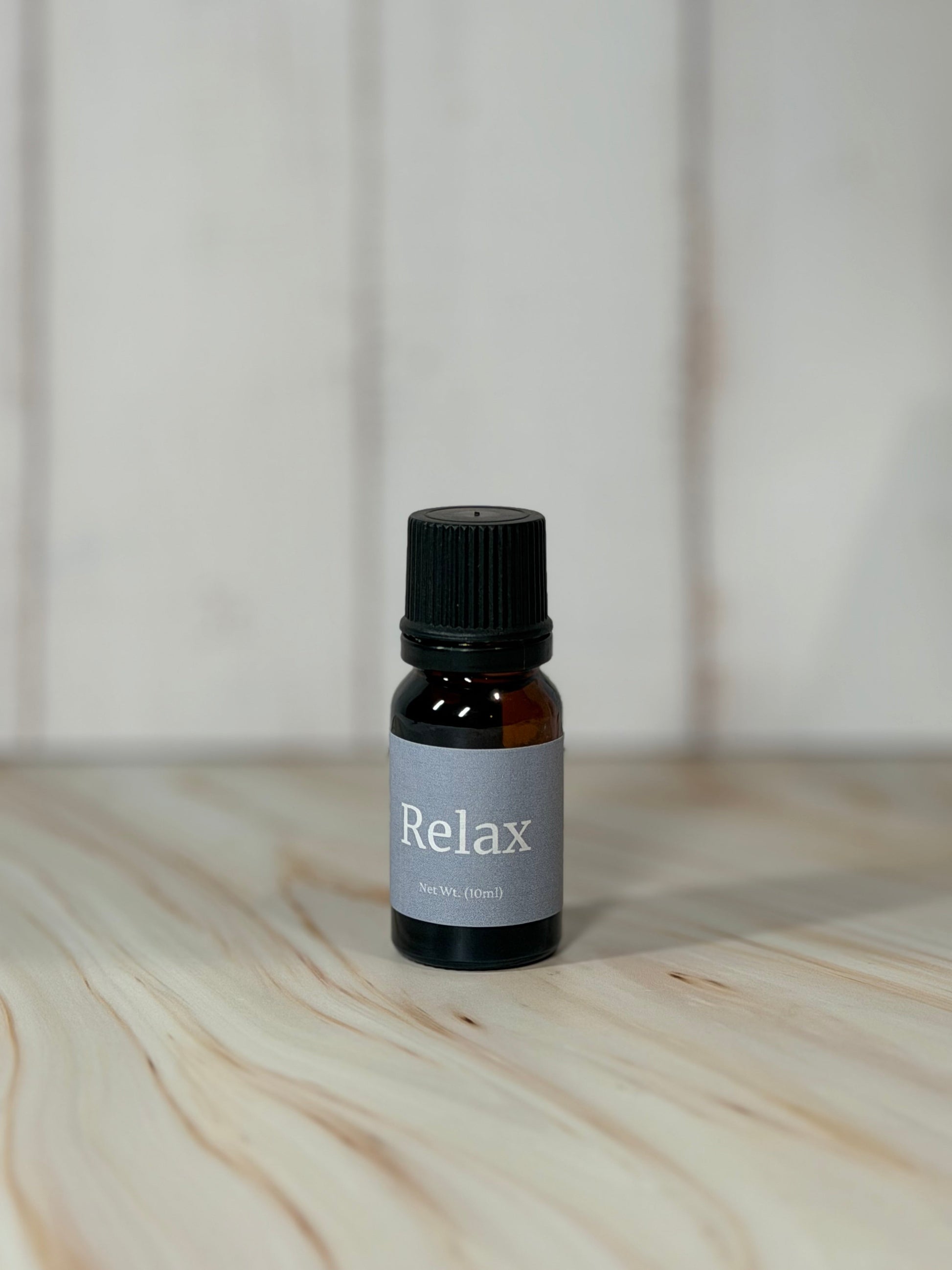 bottle of Relax essential oil blend with eucalyptus spearmint on wooden surface