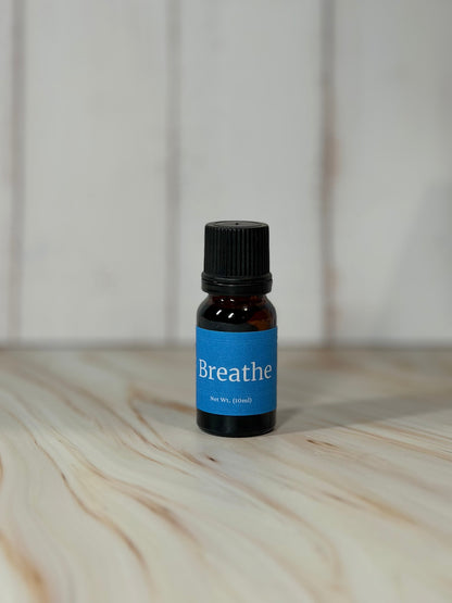 small amber bottle of Breathe essential oil blend with peppermint and lavendermint on wooden surface