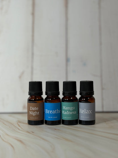 Essential Oil Blend bottles with Relax, Breathe, Date Night, and Mango Madness labels on wooden surface