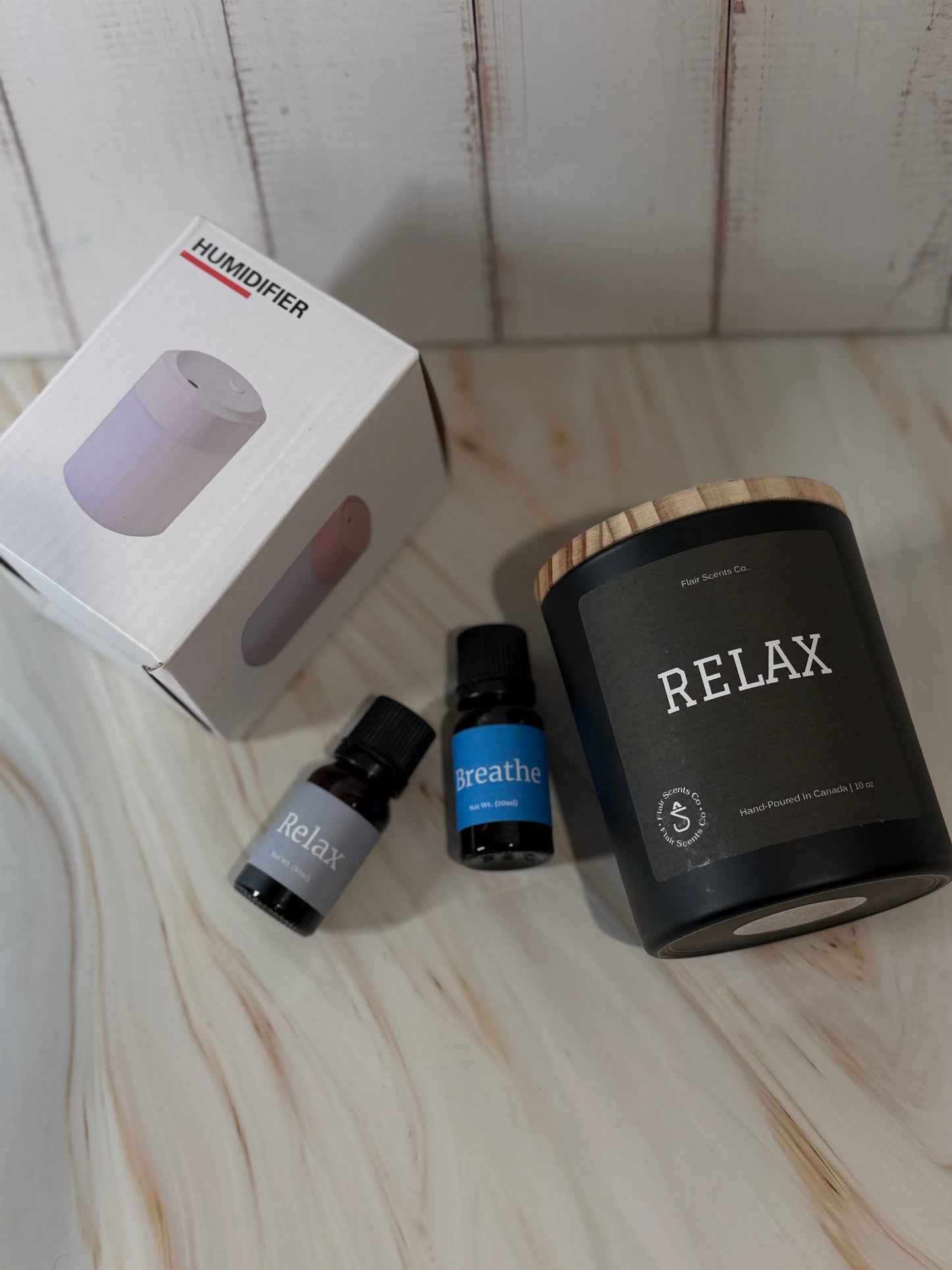 Reset Ritual at-home self-care bundle featuring a calming candle, mini humidifier, and essential oils arranged in a peaceful, minimalist setting.