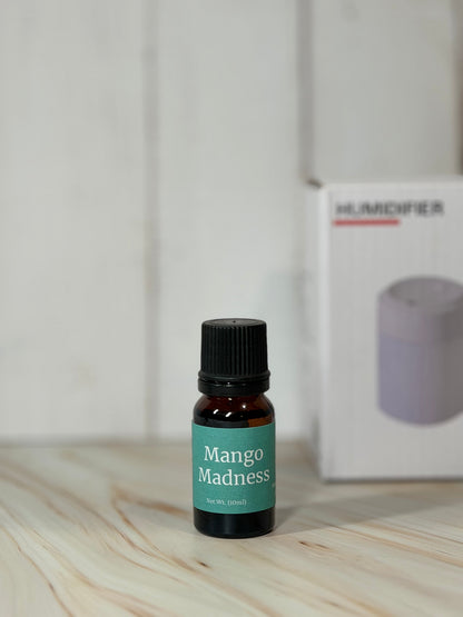 Mango Madness essential oil blend bottle with diffuser in background
