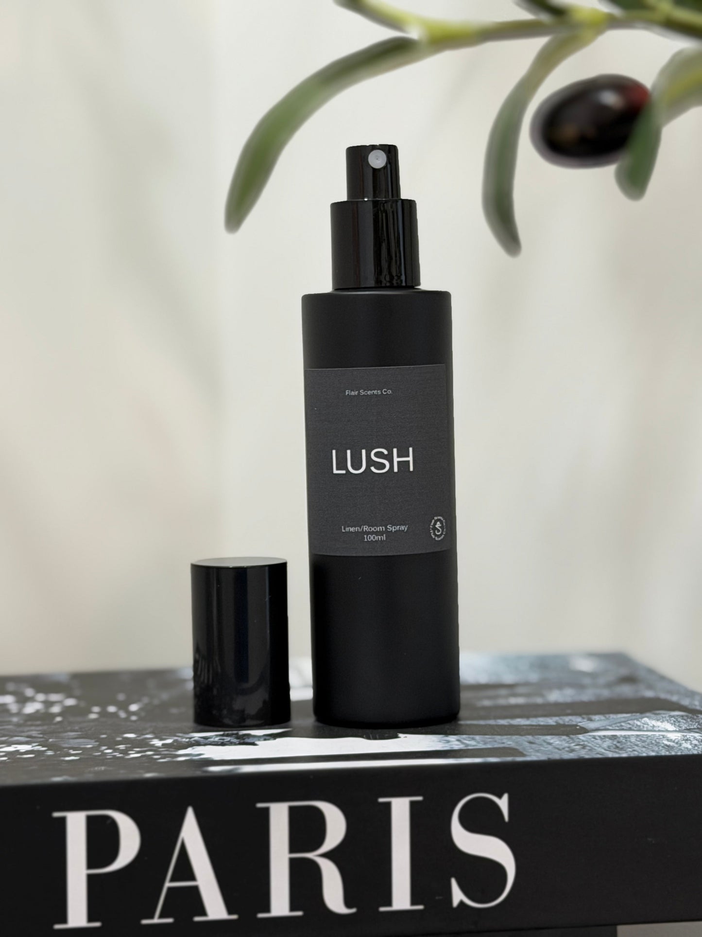 Lush room spray bottle with enchanting scent of patchouli, lavender, and rose petals in black packaging